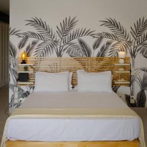 1 dormitorio con 1 cama grande y papel pintado tropical en Studio magnifique vue sur mer, en Saint Martin