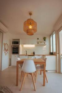 cocina con mesa, sillas y lámpara en Studio magnifique vue sur mer, en Saint Martin