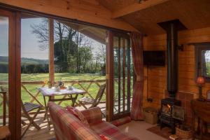 a screened in porch of a cabin with a fireplace at Cedarwood, an intimate and romantic cabin for two. in Icklesham