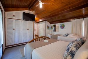ein Schlafzimmer mit 2 Betten und einem TV. in der Unterkunft Pousada Recanto do Arraial in Arraial d'Ajuda
