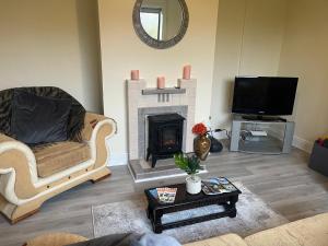 a living room with a fireplace and a tv at An Cnoc in Killorglin