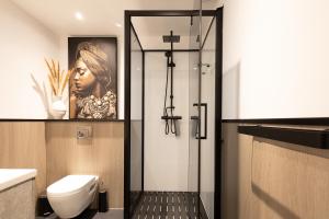 ein Bad mit WC und ein Bild einer Frau in der Unterkunft Het Waterhoentje in Sint Jansklooster + 51 Fotos