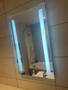 a bathroom mirror with a sink and a shower at Huller and cheese warehouse apartments in Bristol