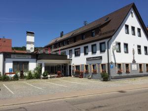 ein großes weißes Gebäude mit Parkplatz in der Unterkunft Hotel Kreuz in Schwäbisch Gmünd