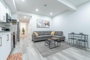カルガリーにあるStylish Getaway 2BD Basement by YMCA and South Health Campus Hospitalのソファとテーブルのあるリビングルーム