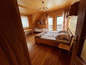 Un dormitorio con una cama en una cabaña de troncos en Domek na Stasince, en Sidzina