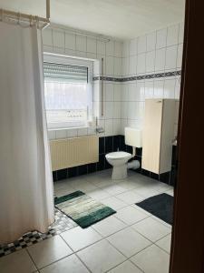 a bathroom with a toilet and a window at Kastner Monteurwohnung 2 in Neubörger