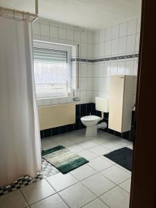 a bathroom with a toilet and a window at Kastner Monteurwohnung 2 in Neubörger +6 photos