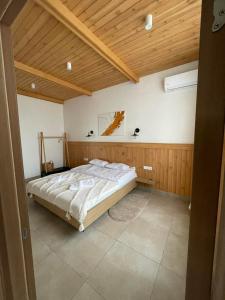 1 dormitorio con cama y techo de madera en Park Rost Club en Zadonetskoye