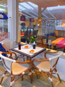 einen Tisch und Stühle mit Teller mit Essen drauf in der Unterkunft Sentrum Hotel in Nordfjordeid