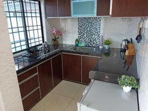 a kitchen with brown cabinets and a counter top at [Georgetown] 2~6 Pax, 3 Bedrooms, 1 Car Park in Jelutong