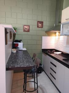 a kitchen with a counter and a table with chairs at Tiny House Perfeita para Casais in Florianópolis