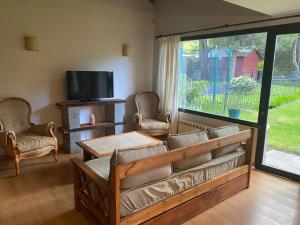 a living room with a couch and chairs and a tv at Casa Las Margaritas II in San Carlos de Bariloche