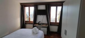 a bedroom with a bed and a desk and windows at Castle view in Veytaux