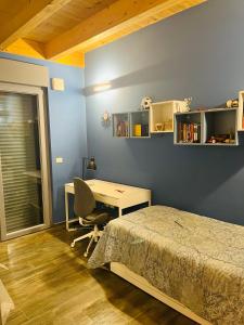 1 dormitorio con cama, escritorio y mesa en Villa di Carlone, en Pianella