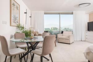 une salle à manger avec une table et des chaises en verre dans l'établissement Sea side relax, à Eilat