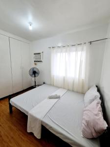 um quarto com uma grande cama branca e uma janela em Calapan Transient Molave L48 em Calapan