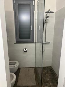 a bathroom with a toilet and a glass shower at Villa di Carlone in Moscufo +15 photos