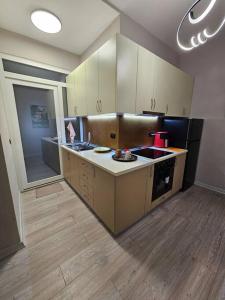 eine Küche mit weißen Schränken und schwarzen Geräten in der Unterkunft Studio near US Embassy with balcony in Tirana