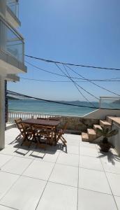 a patio with two picnic tables and the ocean at Pousada Seven in Arraial do Cabo