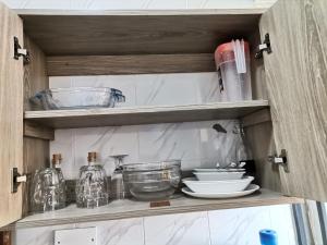 a cupboard with dishes and other kitchen items on it at Millan Homes in Mombasa