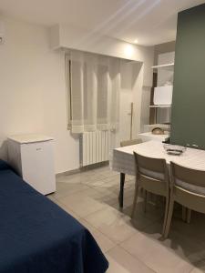 コリリアーノ・カーラブロにあるB&B La Paranzaのベッド、テーブル、椅子が備わる客室です。