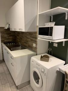 a kitchen with a washing machine and a microwave at B&B La Paranza in Corigliano Calabro