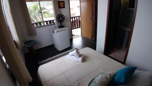 - une chambre avec un lit et une serviette dans l'établissement Pousada Céu de Tucuns, à Búzios