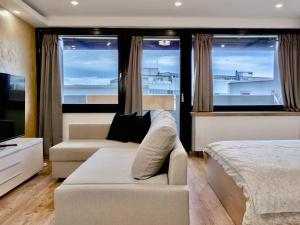 un soggiorno con divano, letto e finestre di NEUES Apartment in Top Lage, free Parking max 1,65m Höhe und 1,8m Breite a Karlsruhe