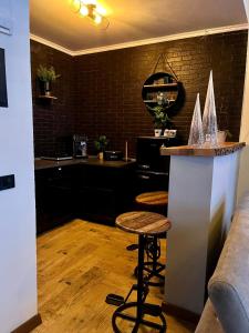 a bar in a kitchen with a counter and a stool at TOP3 in Predeluţ