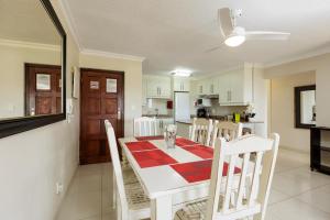 a kitchen and dining room with a table and chairs at Laguna La Crete 34 in Uvongo Beach
