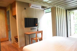 Yatiyantota的住宿－River Pavilion, Kitulgala，卧室配有一张床,墙上配有电视。