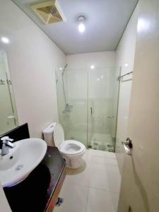 ein Bad mit einem WC, einem Waschbecken und einer Dusche in der Unterkunft Condo in Pasay in Manila