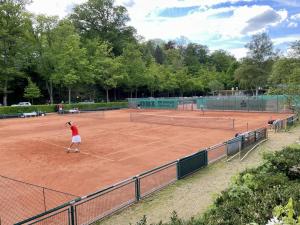 a woman is playing tennis on a tennis court at Apartment - zentrumsnah, eigener Parkplatz und großer Balkon ins Grüne in Baden-Baden