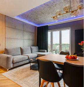 uma sala de estar com um sofá e uma mesa em SKY Home- Wood Penthouse -Manufaktura, Parking, Klimatyzacja, Dostęp na Kod em Lódź