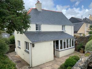 a white house with a garage at The Glen at Ugborough - South Hams Holiday Home in Ugborough