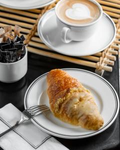 un plato con una pastelería y una taza de café en Albergo Boccadasse en Génova