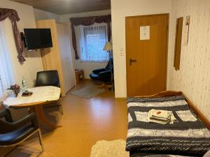 a living room with a couch and a table and a desk at Ferienwohnung Hoffmann in Bad Münder am Deister