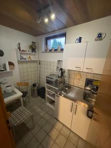 uma pequena cozinha com armários brancos e uma janela em Ferienwohnung Hoffmann em Bad Münder am Deister
