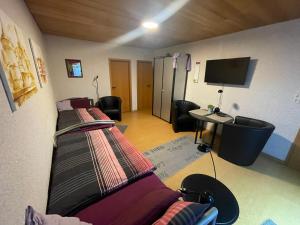 two beds in a room with a desk and a tv at Ferienwohnung Hoffmann in Bad Münder am Deister
