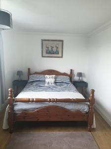 a bed in a bedroom with two lamps at Bader House in Aberporth