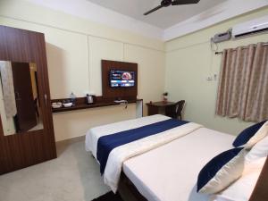 um quarto de hotel com duas camas e uma televisão em THE STAY CORNER em Guwahati