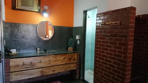 a bathroom with a sink and a shower with a mirror at Pousada Céu de Tucuns in Búzios
