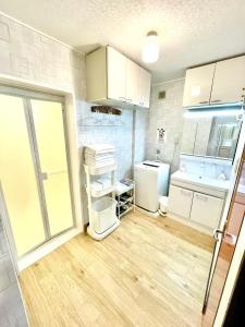 a small kitchen with white cabinets and a refrigerator at 海の眺め/プール付き/炭火BBQ(雨でも可能)/まるまる貸切別荘/最大13名/名勝千畳敷・三段壁近く in Shirahama