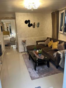 a living room with a couch and a table at Appartement à 10 minutes du Stade de France in Saint-Denis