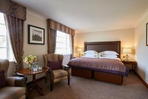 a hotel room with a bed and a chair at Macdonald Drumossie Hotel Inverness in Inverness