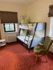 クアオルト・オーバーヴィーゼンタールにあるNeues Haus - Berggasthof und Hotelの二段ベッド2台と椅子が備わる客室です。