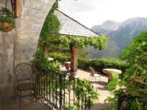 a patio with a table and chairs and mountains at Casa Rural Fontamil in Gistaín