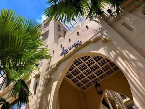 a building with a palm tree in front of it at Dewan Bangkok - SHA Certified in Bangkok