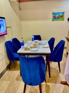 un tavolo con sedie blu e piatti di cibo sopra di Hotel Inn Gulistan-e-Jhour a Karachi